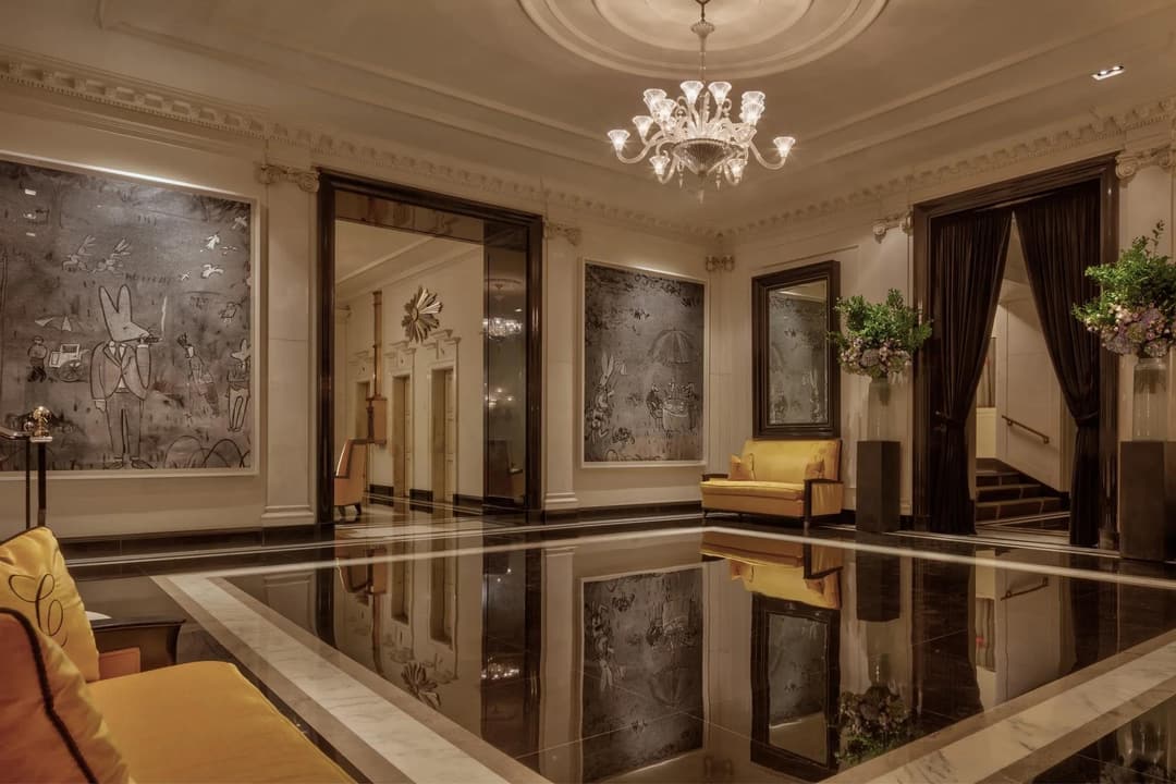 Mirrored marble foyer with a chandelier and wall artwork at The Carlyle