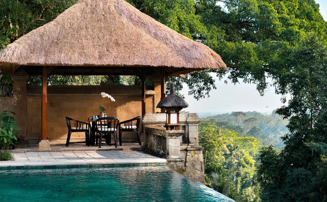 Open-air dining bale at Amandari with thatched roof, overlooking Balinese landscape and plunge pool