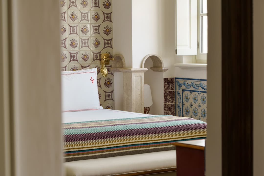 Elegant bed in a sunlit guest room at a Relais & Châteaux resort in Melides, Alentejo, Vermelho Melides