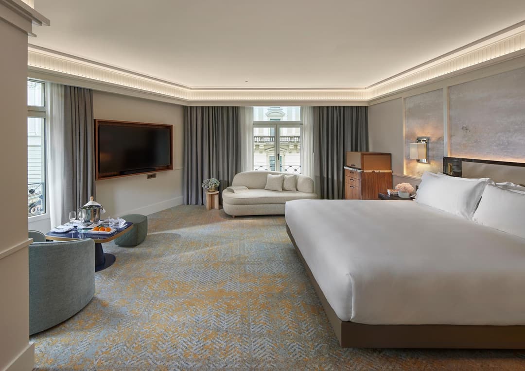 Bedroom with a large bed, sofa and armchairs at Mandarin Oriental Savoy, Zurich
