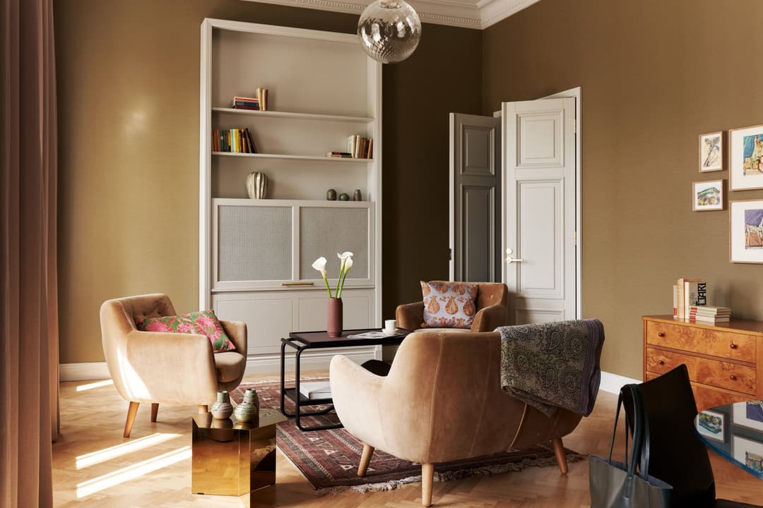 Living room with armchairs, bookcase and framed prints at Hotel St George, Helsinki