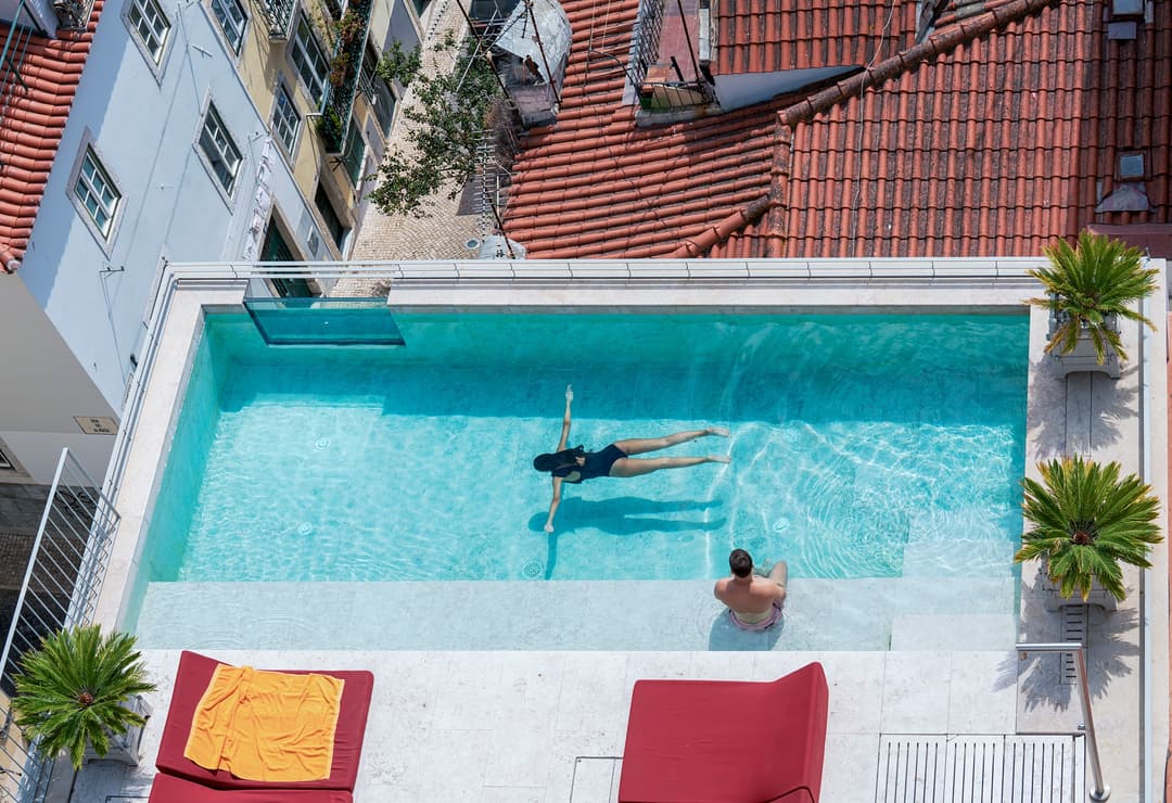 Aerial view of guests relaxing in the boutique outdoor swimming pool at Verride Santa Catarina, Verride Palacio de Santa Catarina