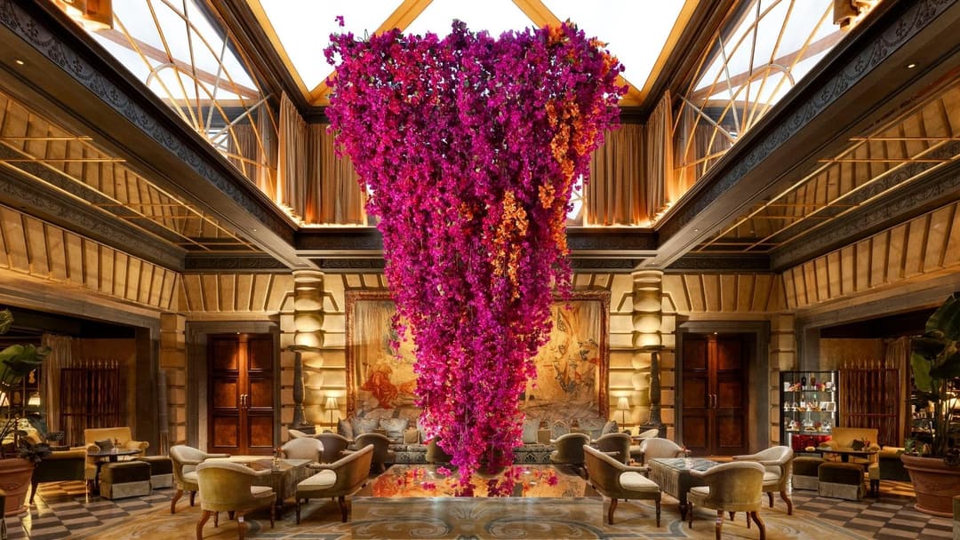 Lounge with a tall pink bougainvillea display under a glass roof at Hôtel Métropole Monte-Carlo