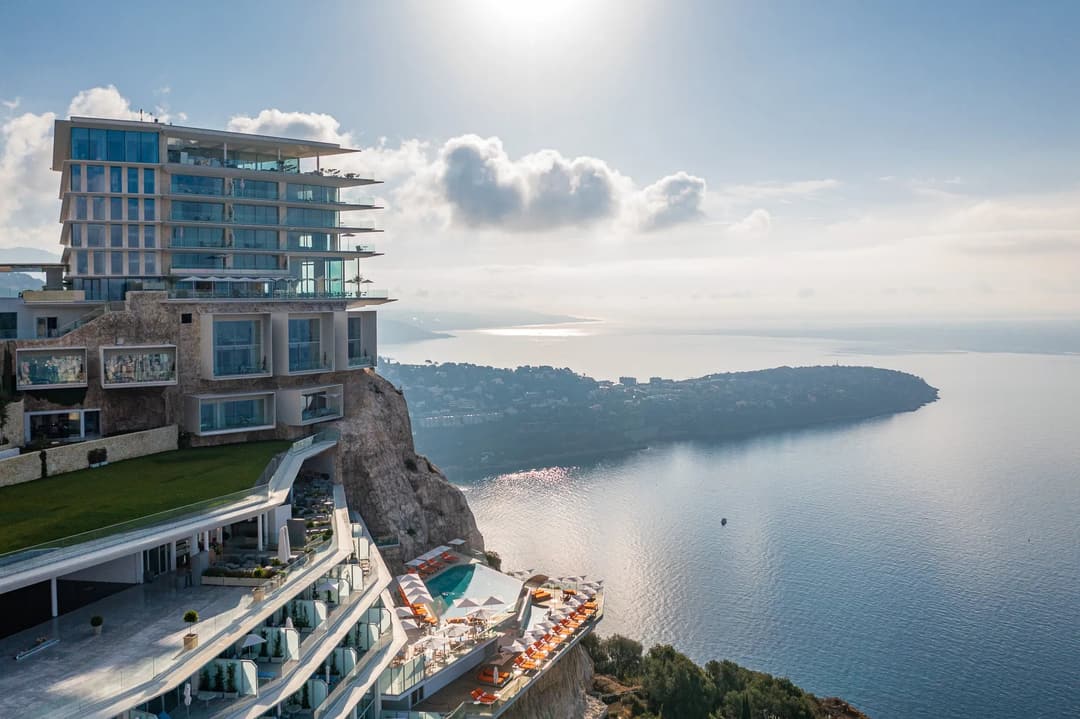 Clifftop hotel with terraced levels, a pool deck, and panoramic views over the sea and coastline.