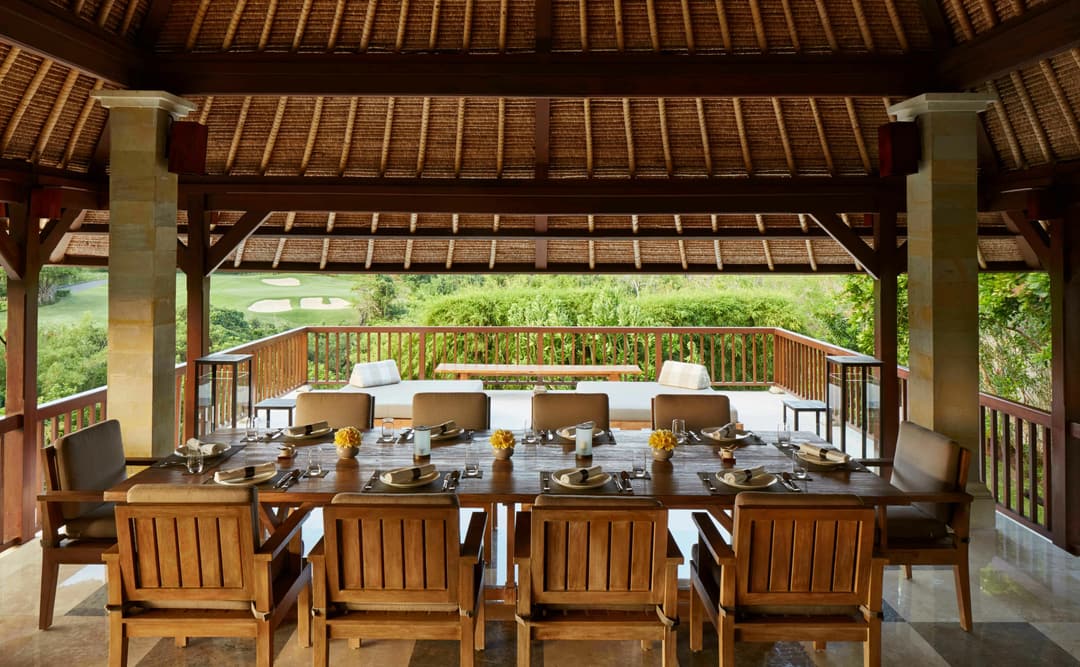 Dining pavilion at Aman Villas at Nusa Dua with wooden furnishings and garden views