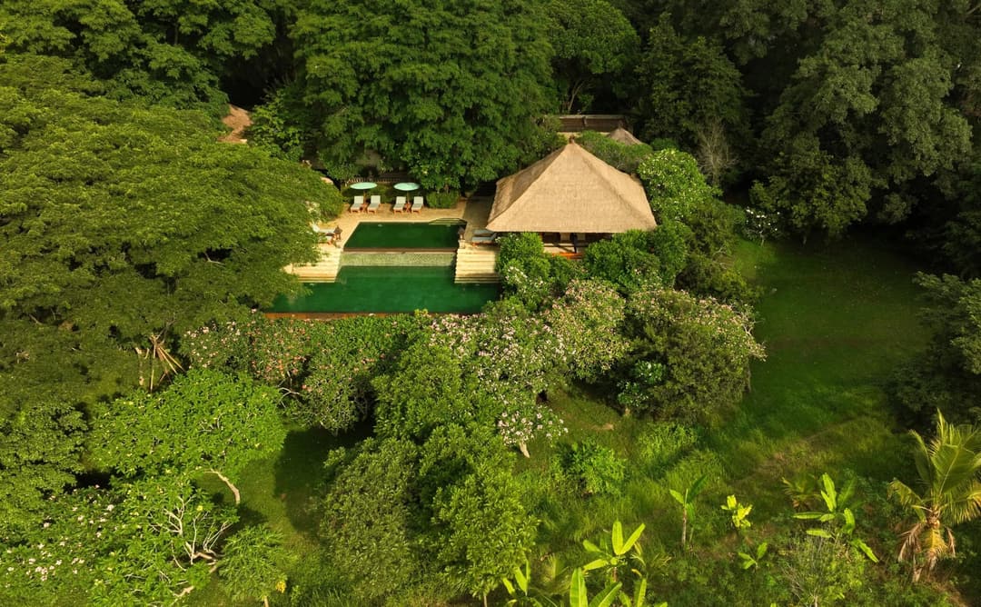 Aerial view of a three-bedroom villa at Amandari surrounded by lush green rice terraces in Indonesia
