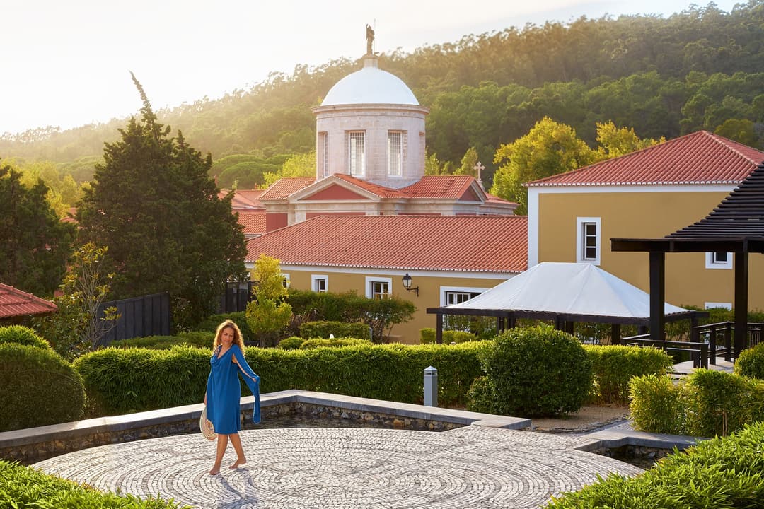 A woman walks the circular pattern of a large stone path, Penha Longa Resort, Sintra