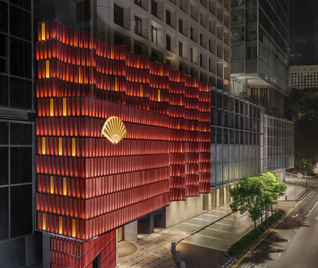 Night view of a modern building with illuminated red and orange exterior lighting and a decorated facade, The Landmark Mandarin Oriental, Hong Kong
