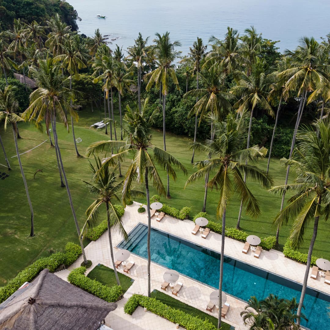 Aerial view of Amankila's pool surrounded by tropical gardens and palm trees in Indonesia, Manggis (East Bali)