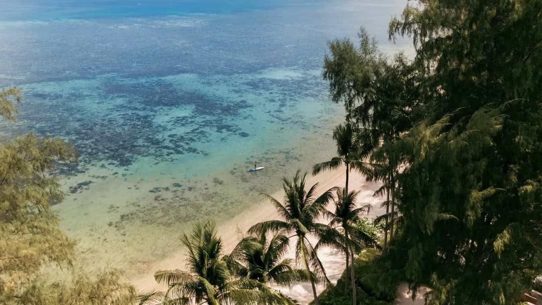 Aerial view of tropical Phuket beach with turquoise water and palm trees, Rosewood Phuket