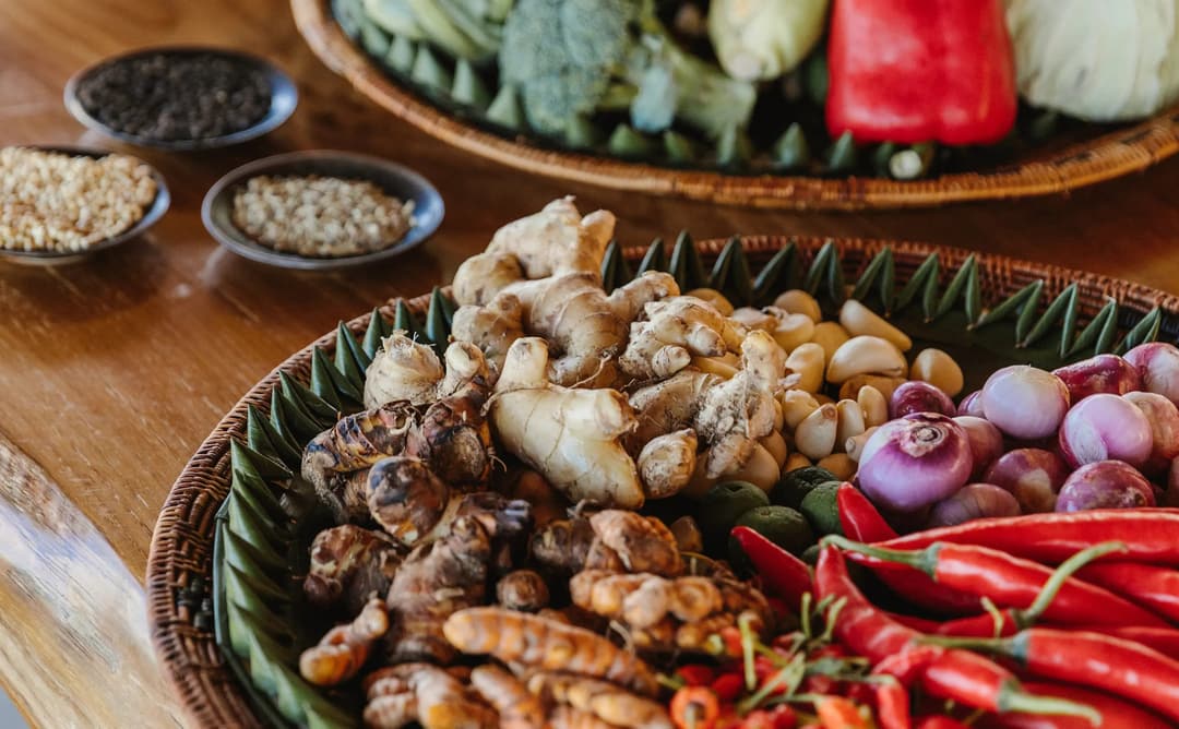 Ingredients and spices arranged on a wooden table at Aman Villas at Nusa Dua cooking class