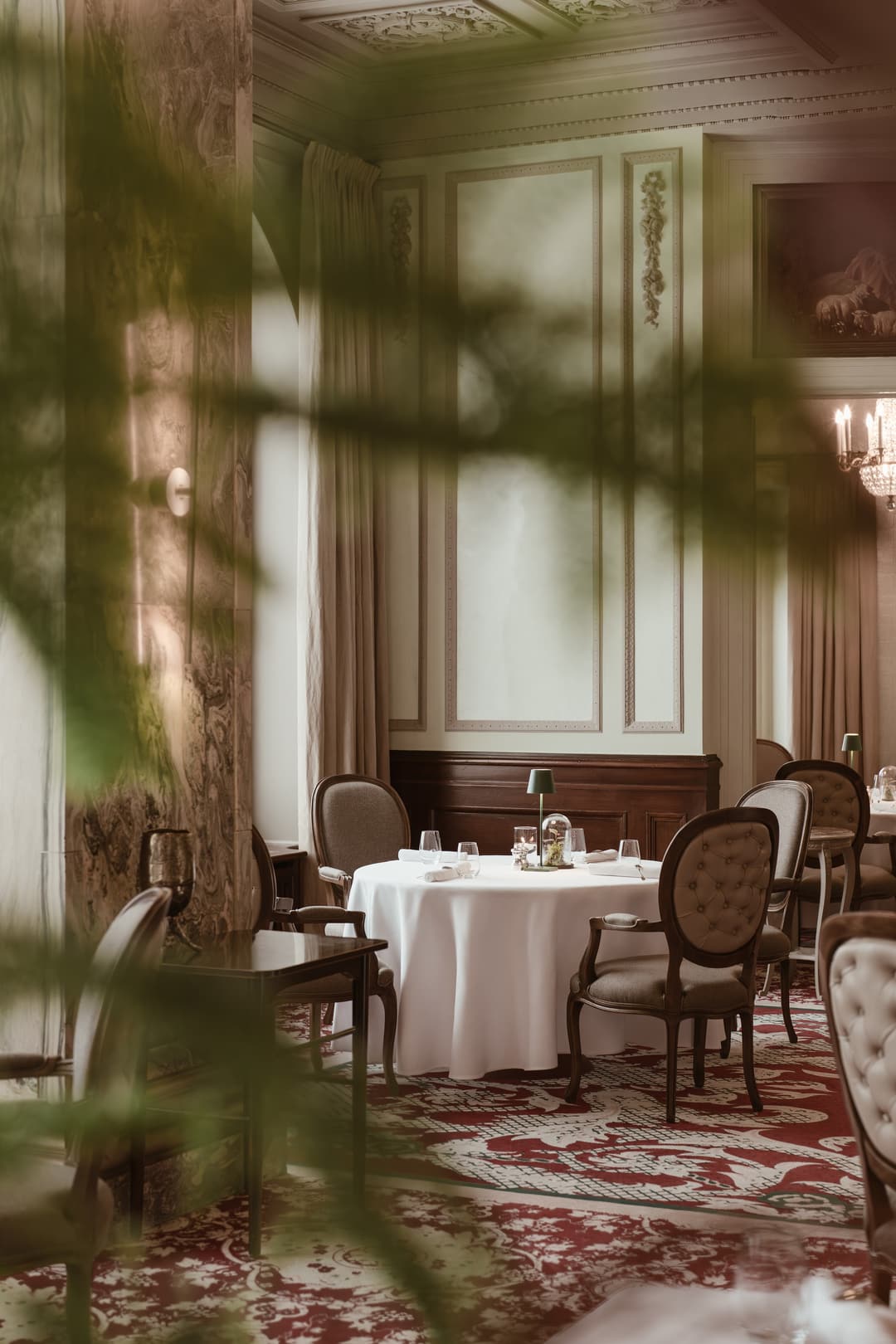 An elegantly set round restaurant table in radiant white, perfectly arranged for an exclusive dinner ambiance, Carlton Hotel St. Moritz