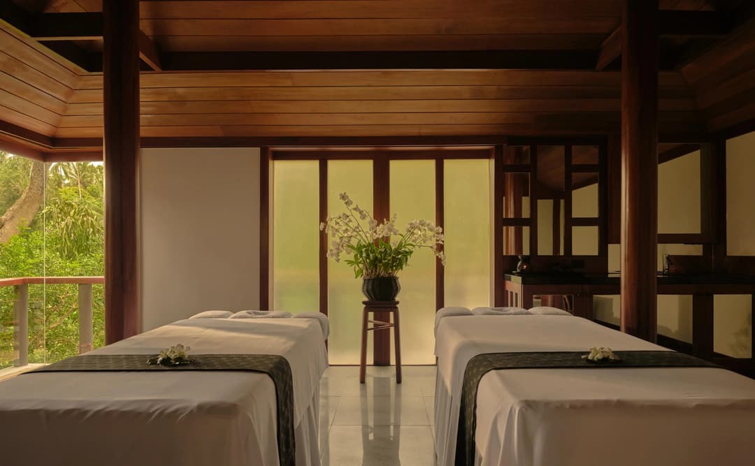 Double treatment room at Amanpuri's spa house in Thailand, featuring two massage beds and serene interior design