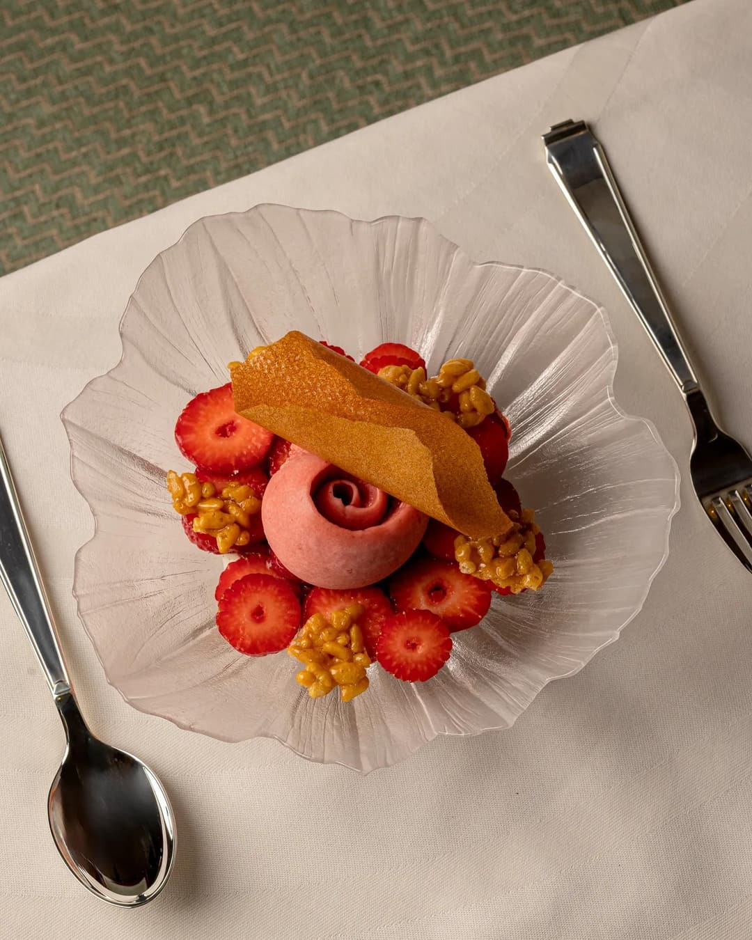Strawberry dessert with pink sorbet, sliced strawberries and caramelised clusters on a glass plate, Claridge's