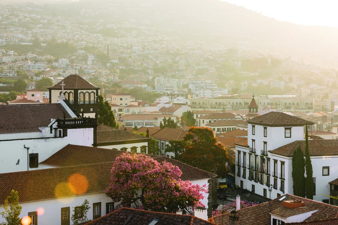 Hazy view over the white and terracotta buildings of Funchal's old town and suburbs, which cover the surrounding slopes, Reid's Palace, A Belmond Hote